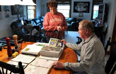 Diane and Barry Funfar look at photos of flowers of their once-flourishing gardens.